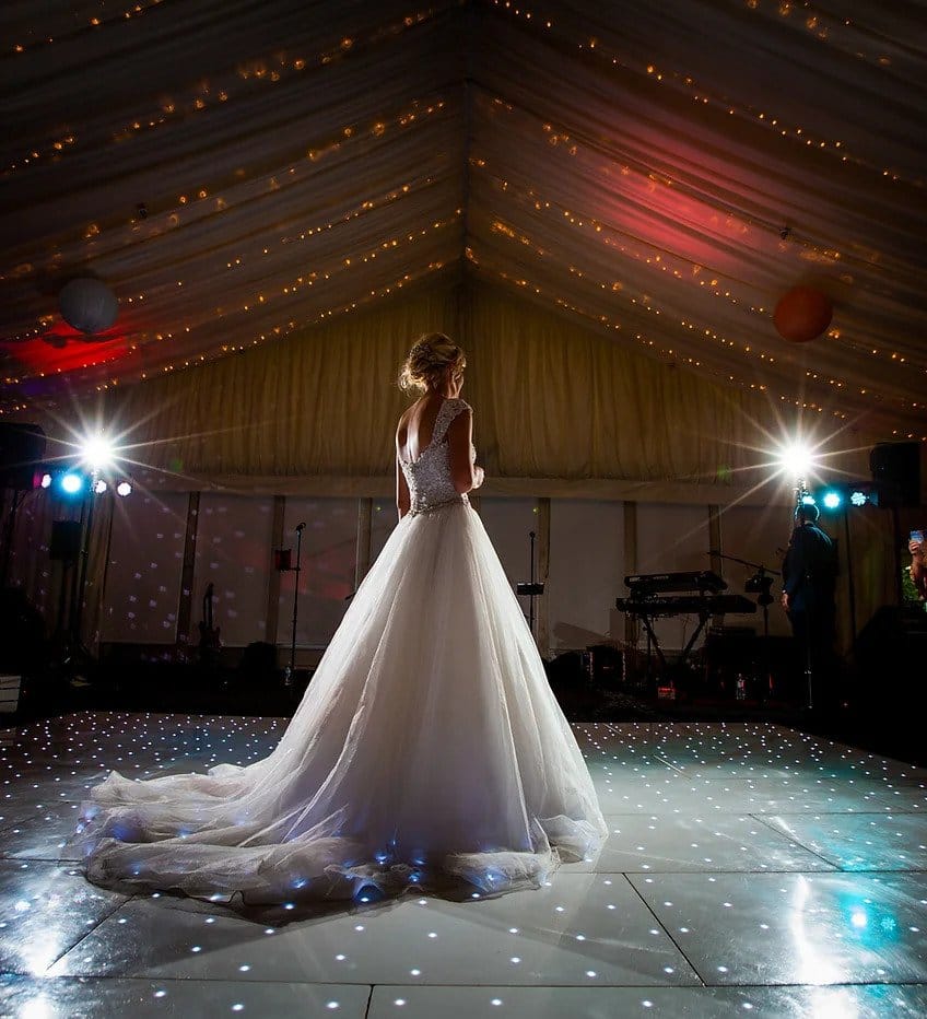 bride stood on dancefloor inside the marquee at forest of arden